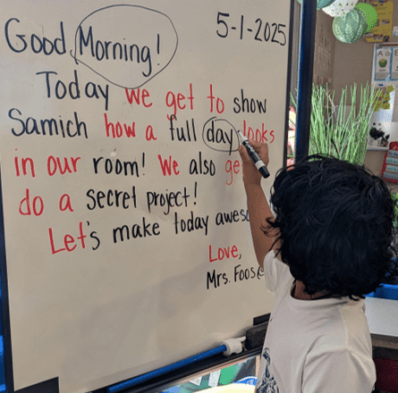Child interacts with text during the Morning Message routine.
